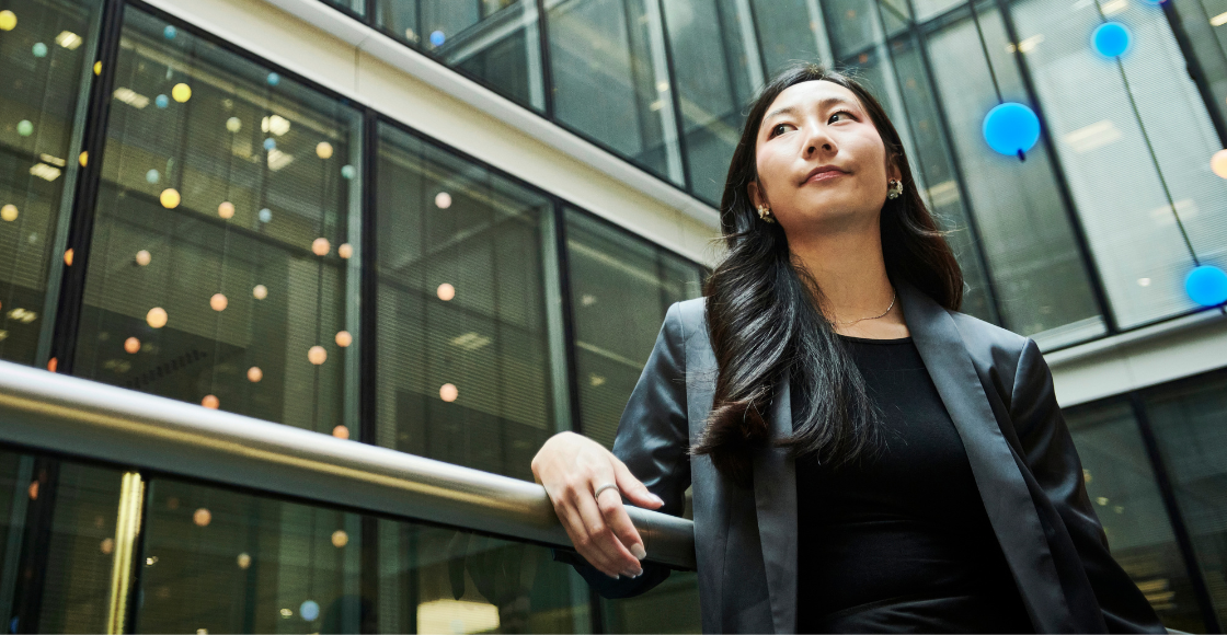 A professional stood outside of the office, looking towards the sky.