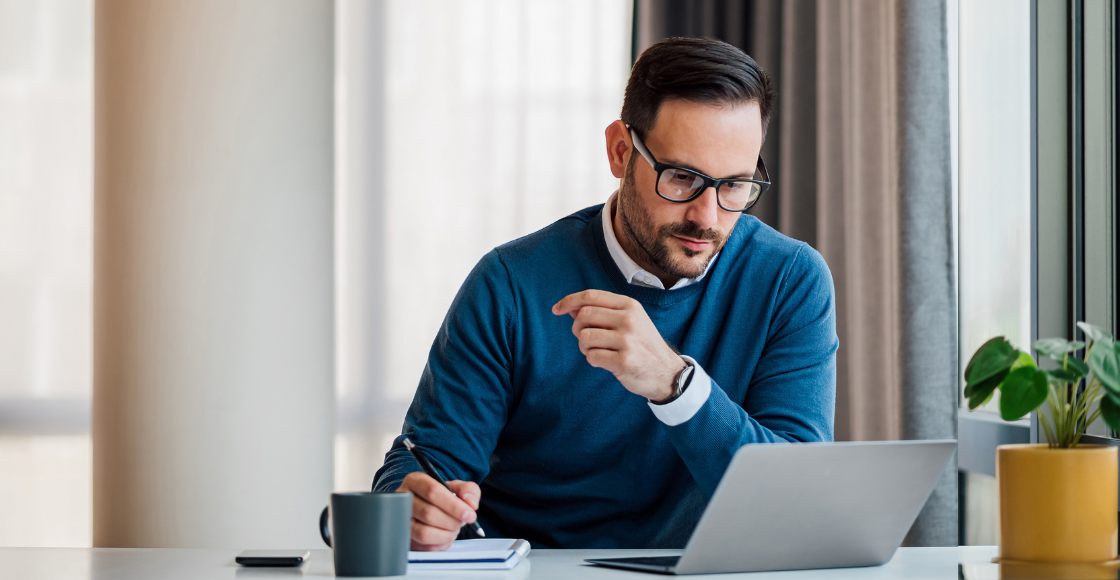 A professional sat in an office and working on a laptop.