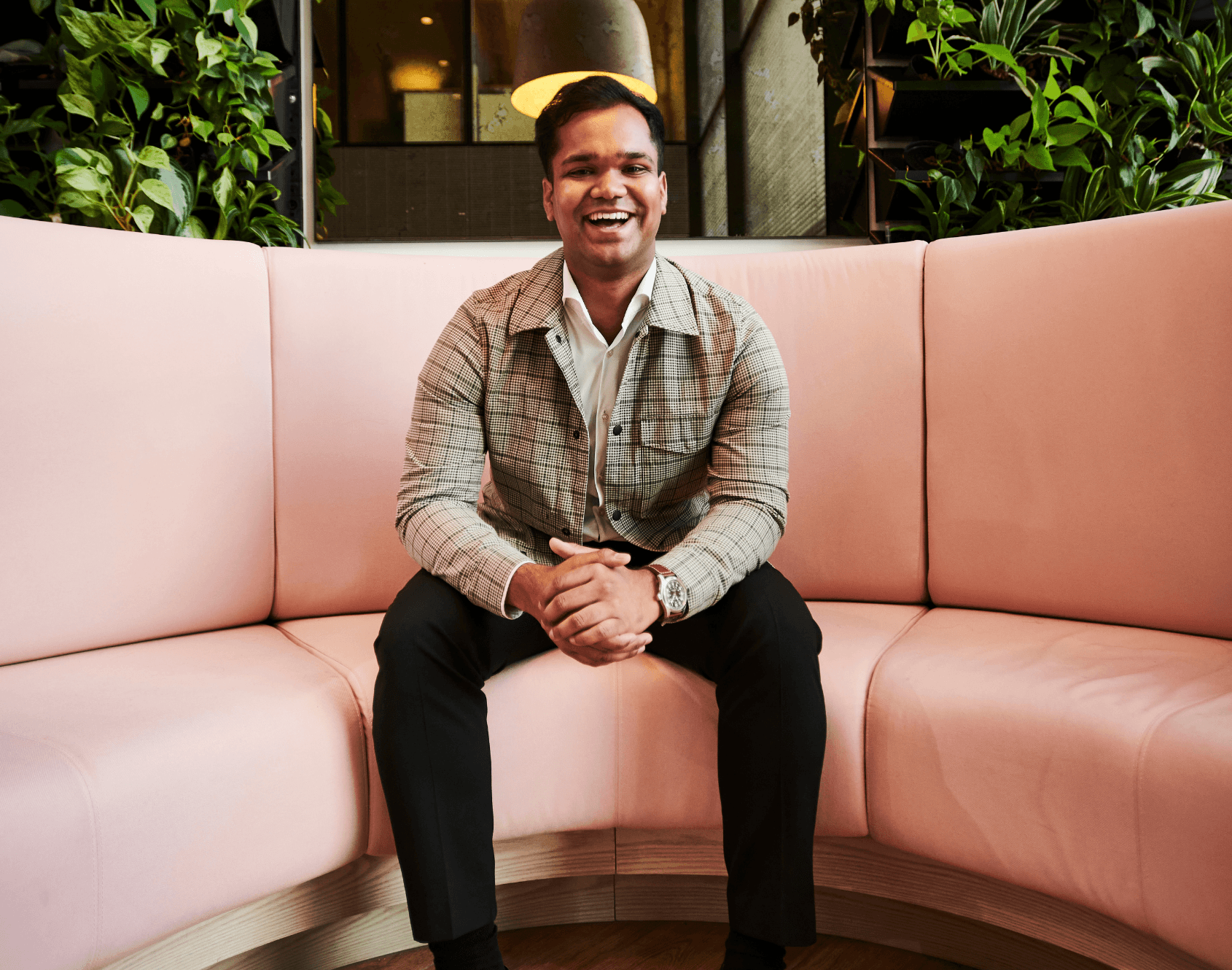 A professional smiling while seated in an office environment.