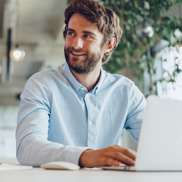 A professional smiling while seated in an office environment.