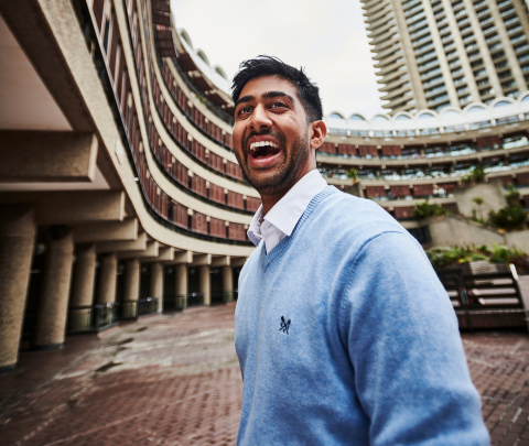 A professional smiling outside of the office.