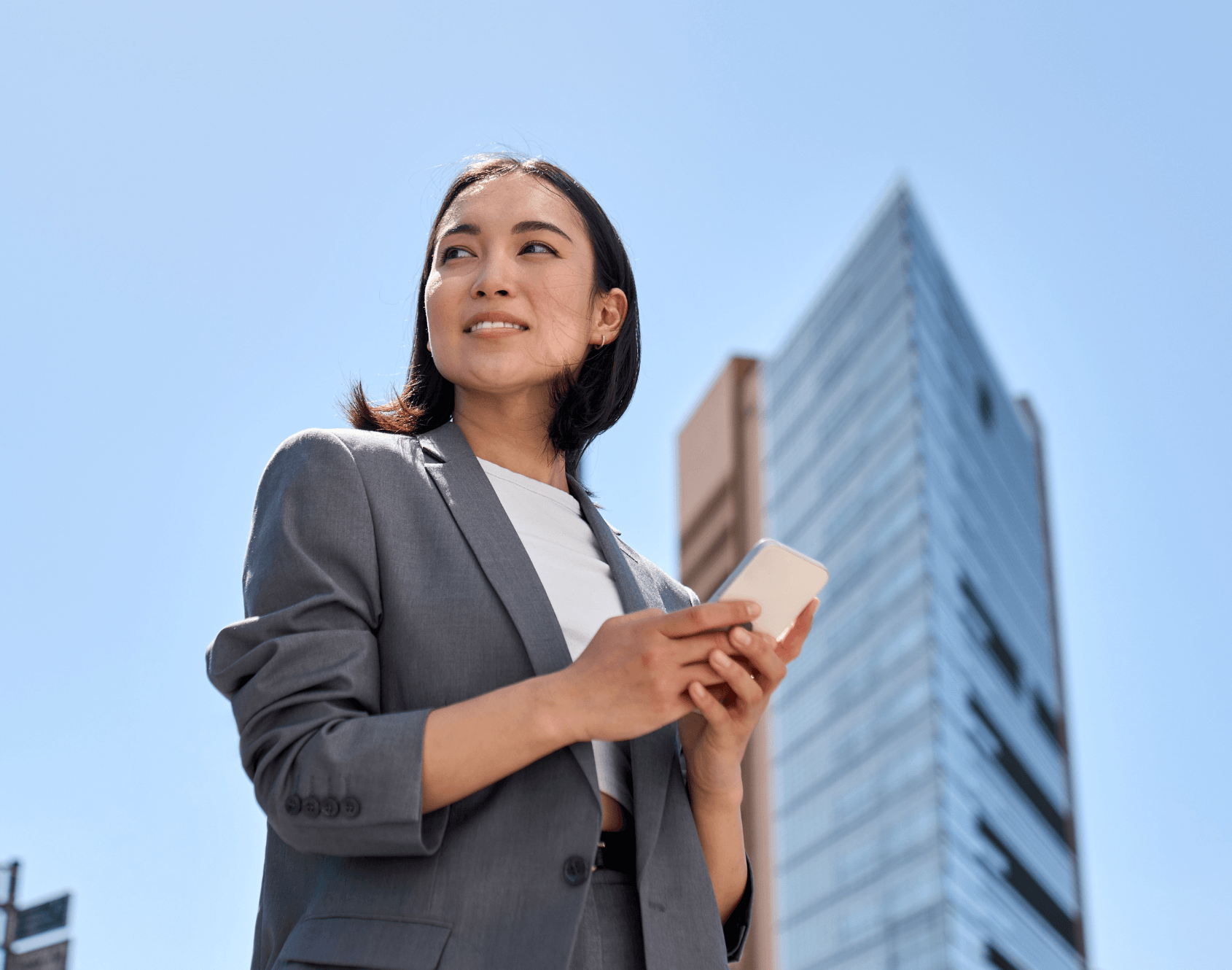 A professional standing outside of the office, looking up.