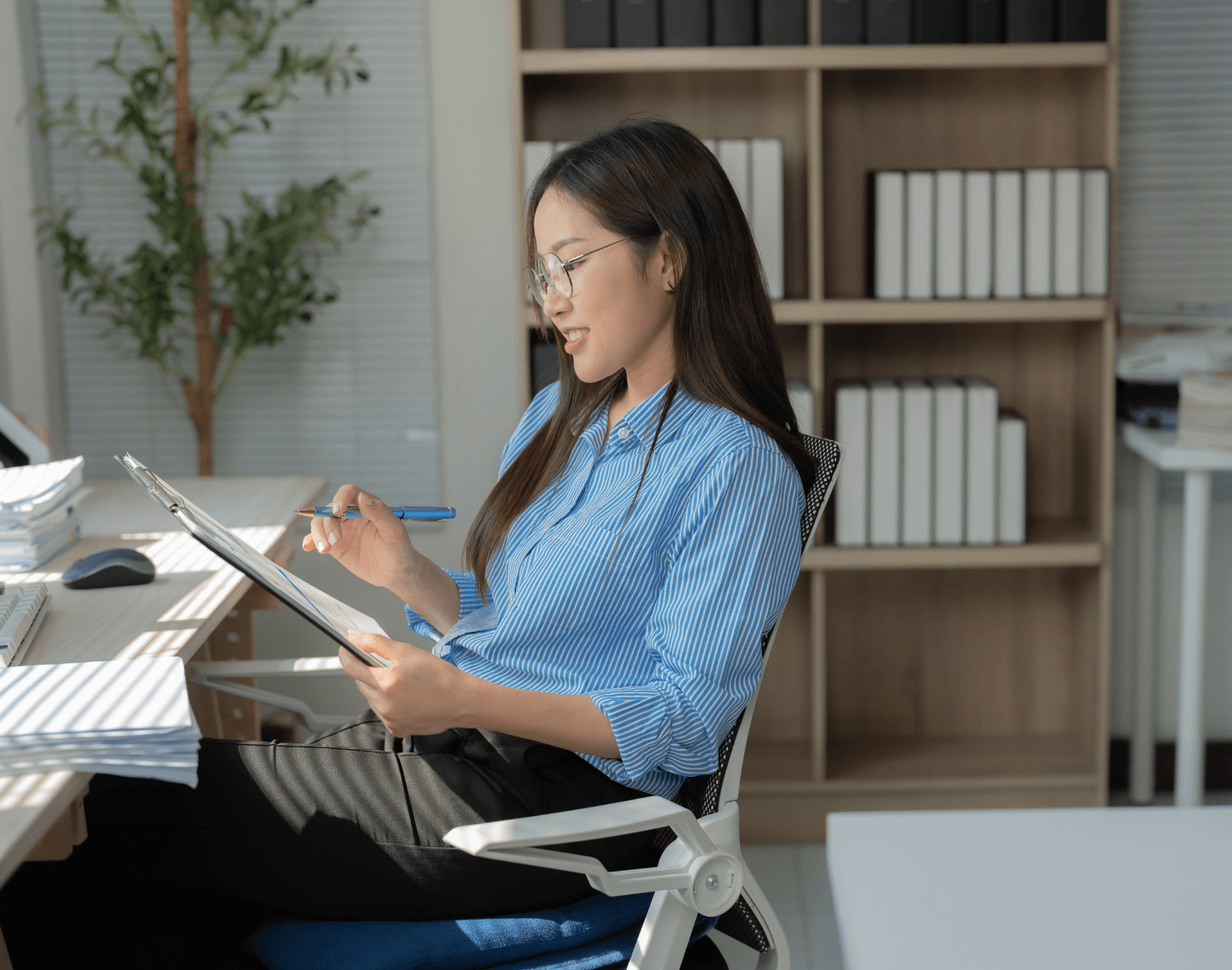 A professional smiling while seated at a work desk.