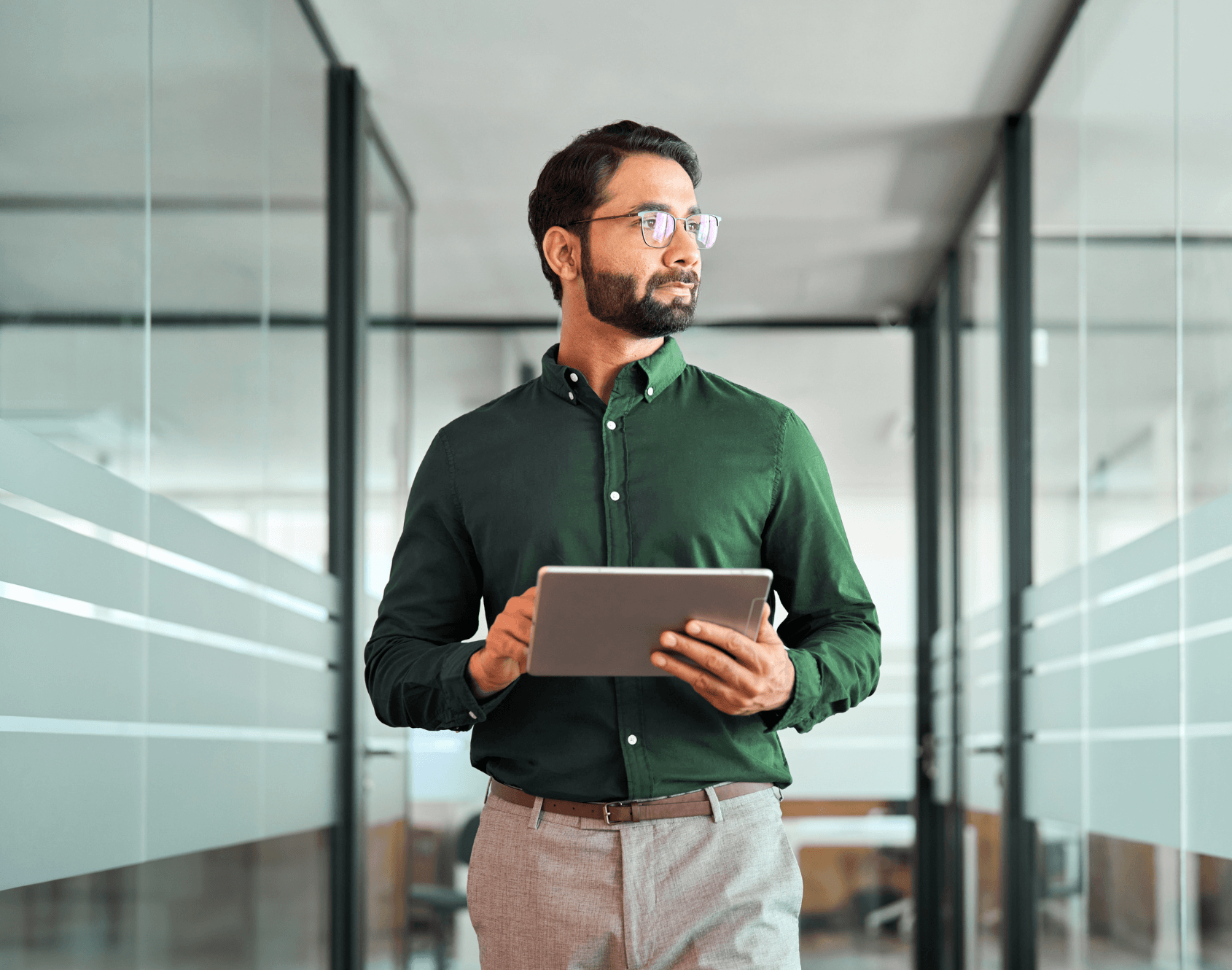 A professional in a modern office holding a notebook.