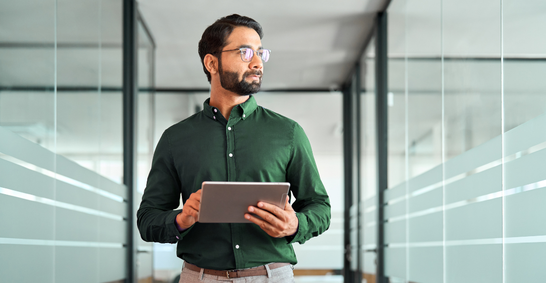 A professional in a modern office holding a notebook.
