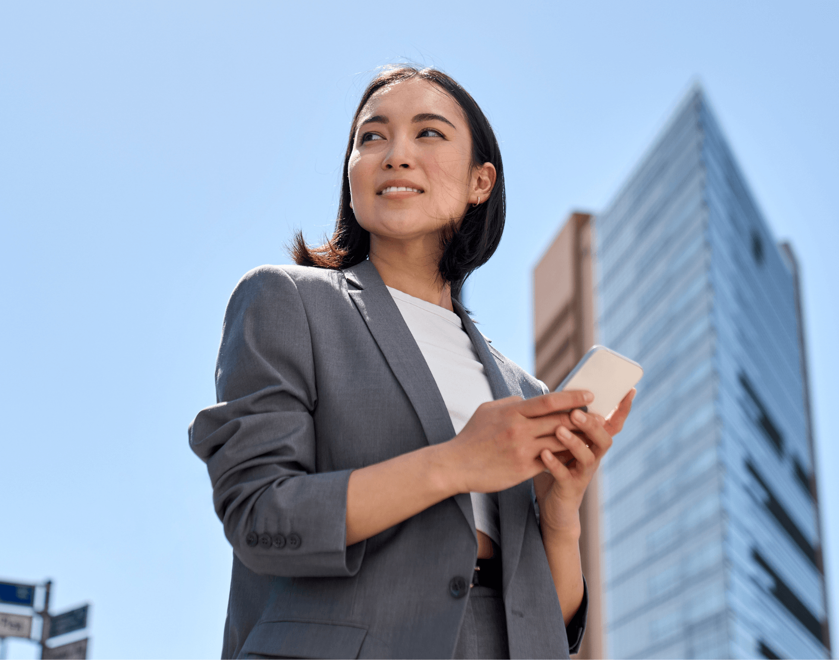A professional walking outside of the office, looking towards the sky.