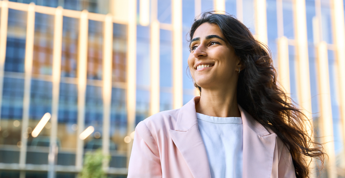A professional smiling outside of the office.