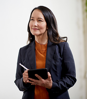 A professional in a modern office holding a notebook.