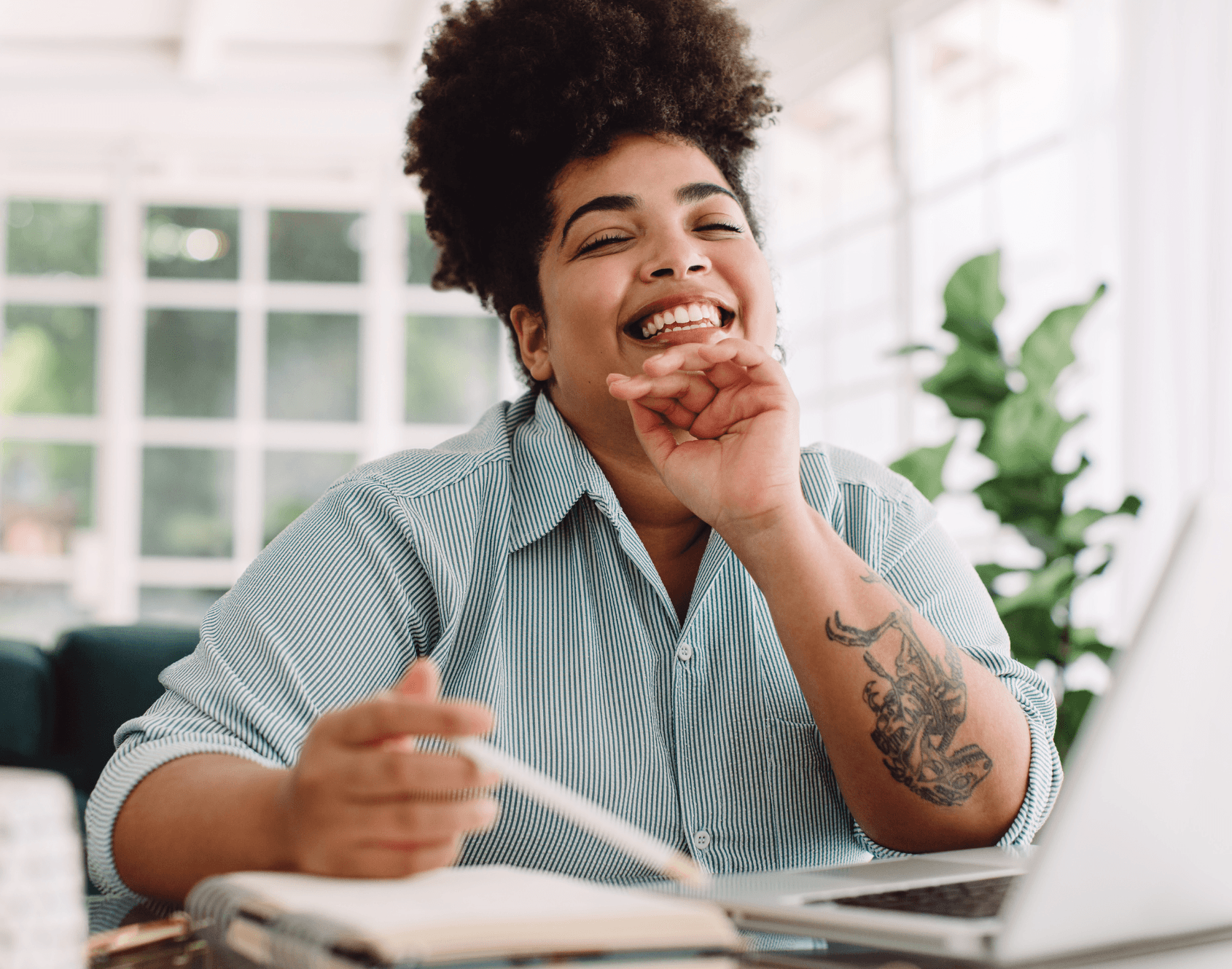 A professional smiling while seated in an office environment.