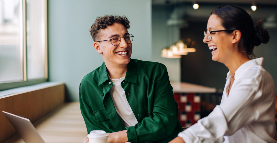 Two colleagues engaged in a conversation in an office environment.