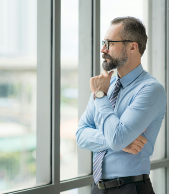 A professional looking out of the office window.
