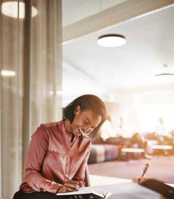 A professional smiling while seated in an office environment.