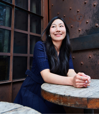 A professional smiling while seated in an office environment.