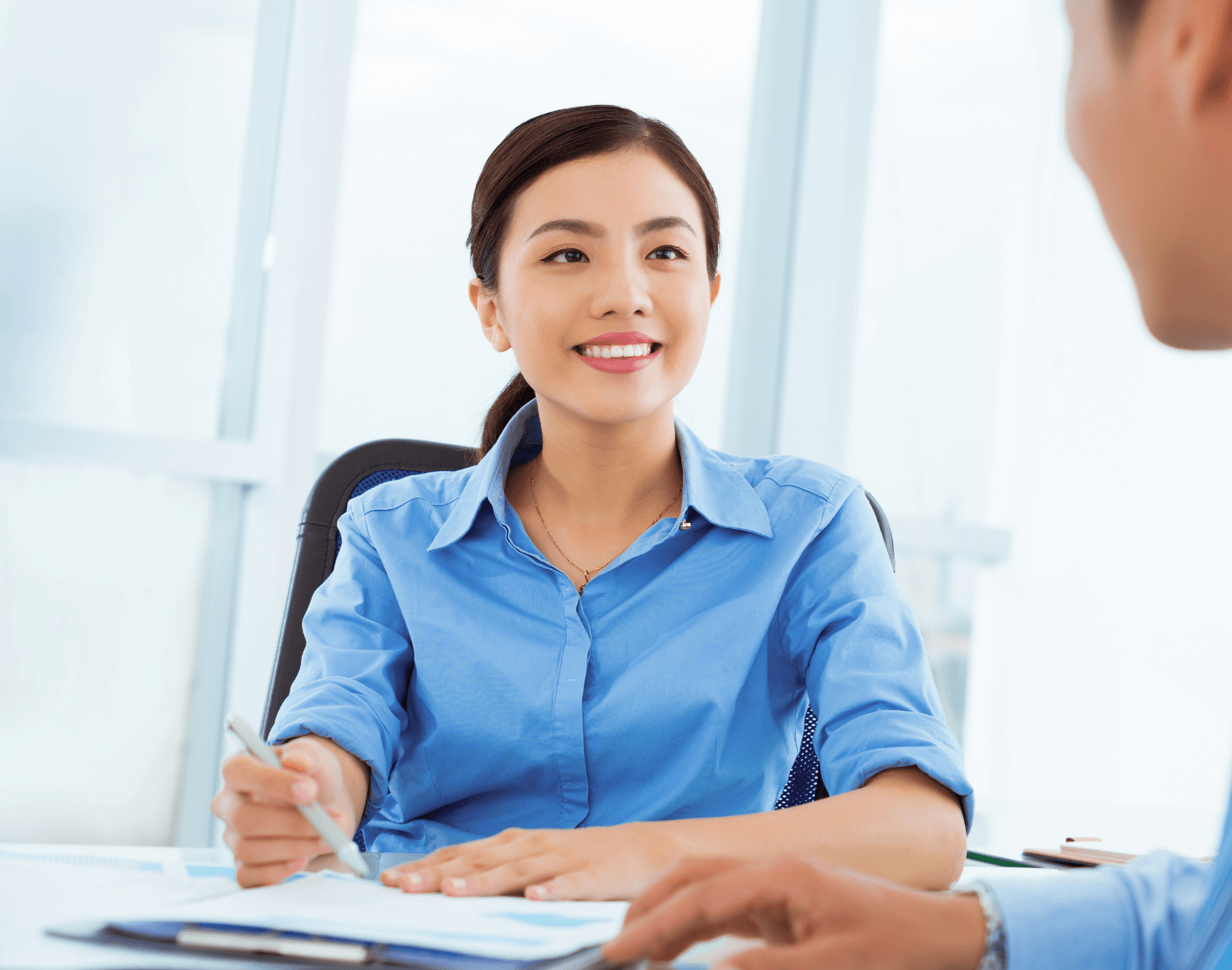 Two colleagues engaged in a conversation in an office environment.
