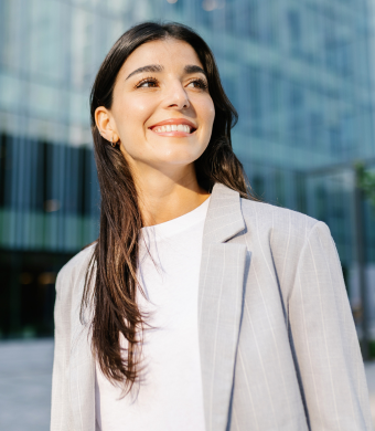 A professional smiling while stood in an office environment.