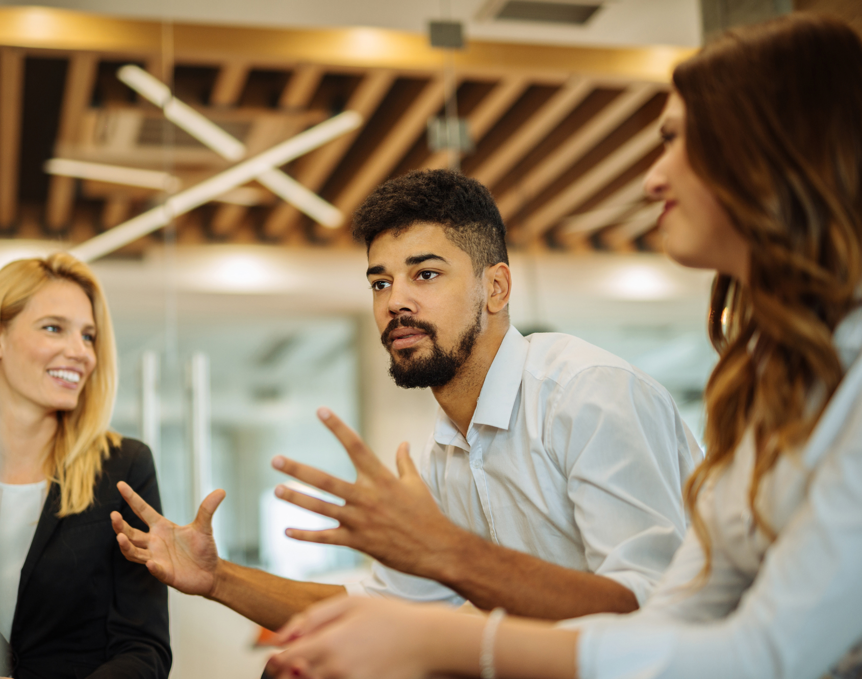 A group of professionals seated in a modern office space, engaged in conversation.