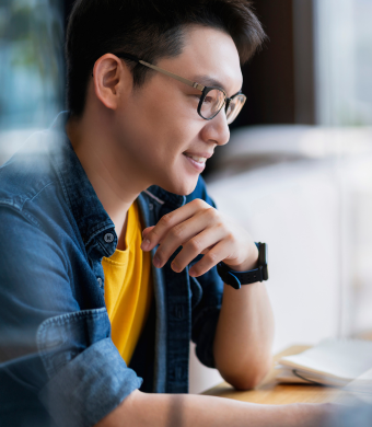 A professional smiling while seated in an office environment.