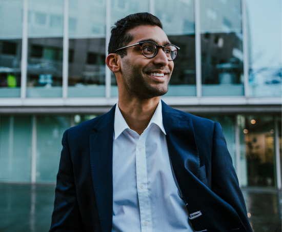 A professional smiling outside of the office.