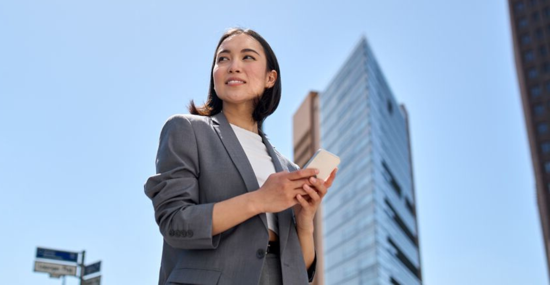 A professional walking outside of the office, looking towards the sky.