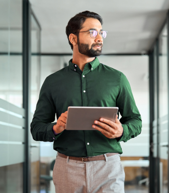 A professional in a modern office holding a notebook.