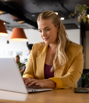 A professional smiling while seated in an office environment.