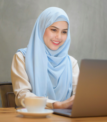 A professional smiling while seated in an office environment.
