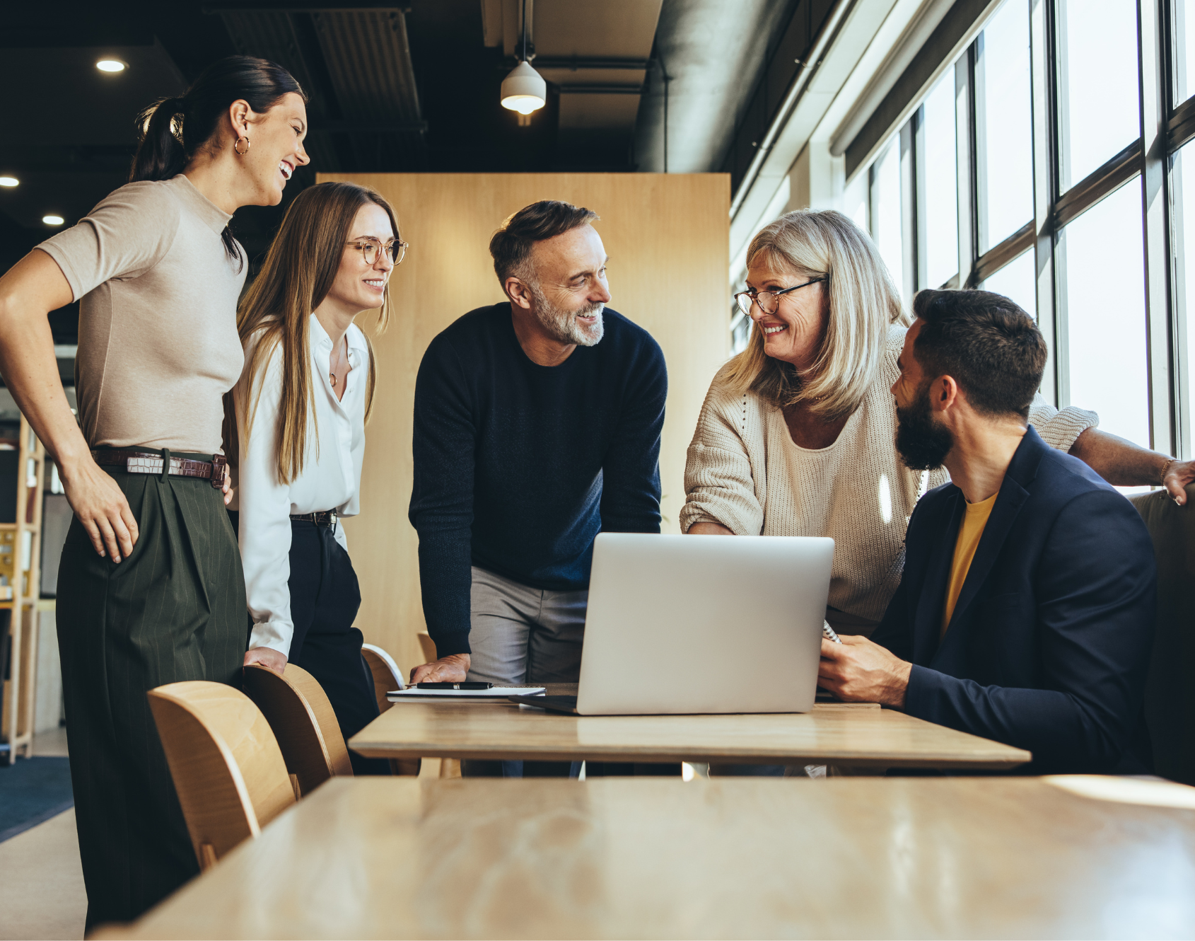 A group of professionals seated in a modern office space, engaged in conversation.