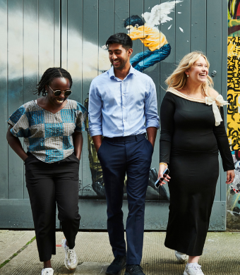 A group of colleagues laughing together outside of the office.