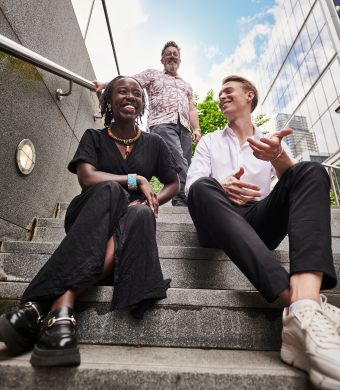 A group of colleagues laughing together outside of the office.