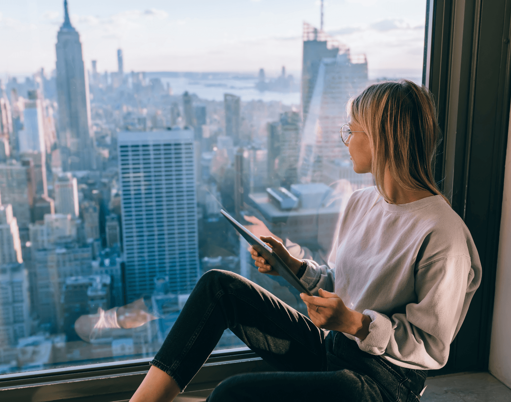 A professional looking out at the view from the office.