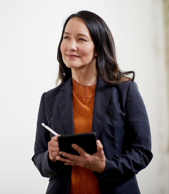 A professional in a modern office holding a notebook.