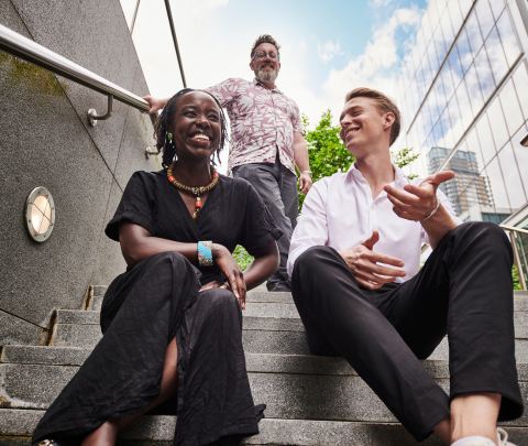 A group of colleagues engaged in conversation outside of the office.