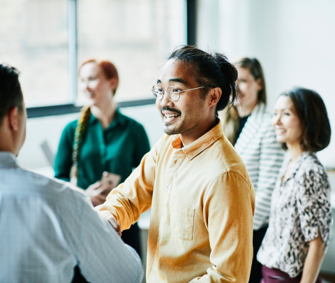 A group of professionals in a workplace setting, reflecting a collaborative work environment.