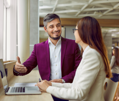 Two colleagues engaged in a conversation in an office environment.