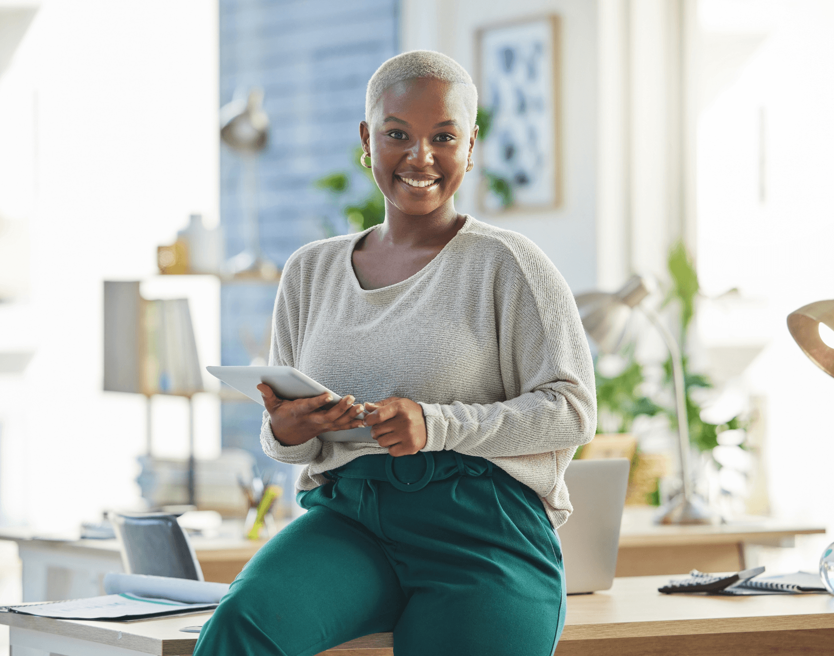 A professional smiling while seated in an office environment.