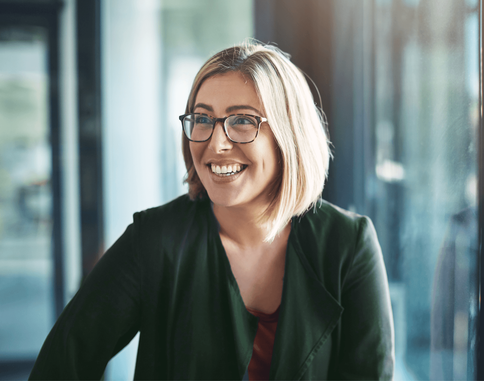 A professional smiling while seated in an office environment.