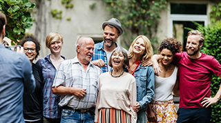 Groupe de personnes de différents âges réunies à l’extérieur dans une ambiance conviviale.