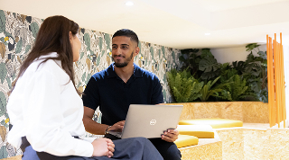 Deux collègues en discussion avec un ordinateur portable
