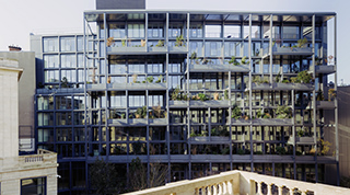 Immeuble moderne en verre avec balcons végétalisés