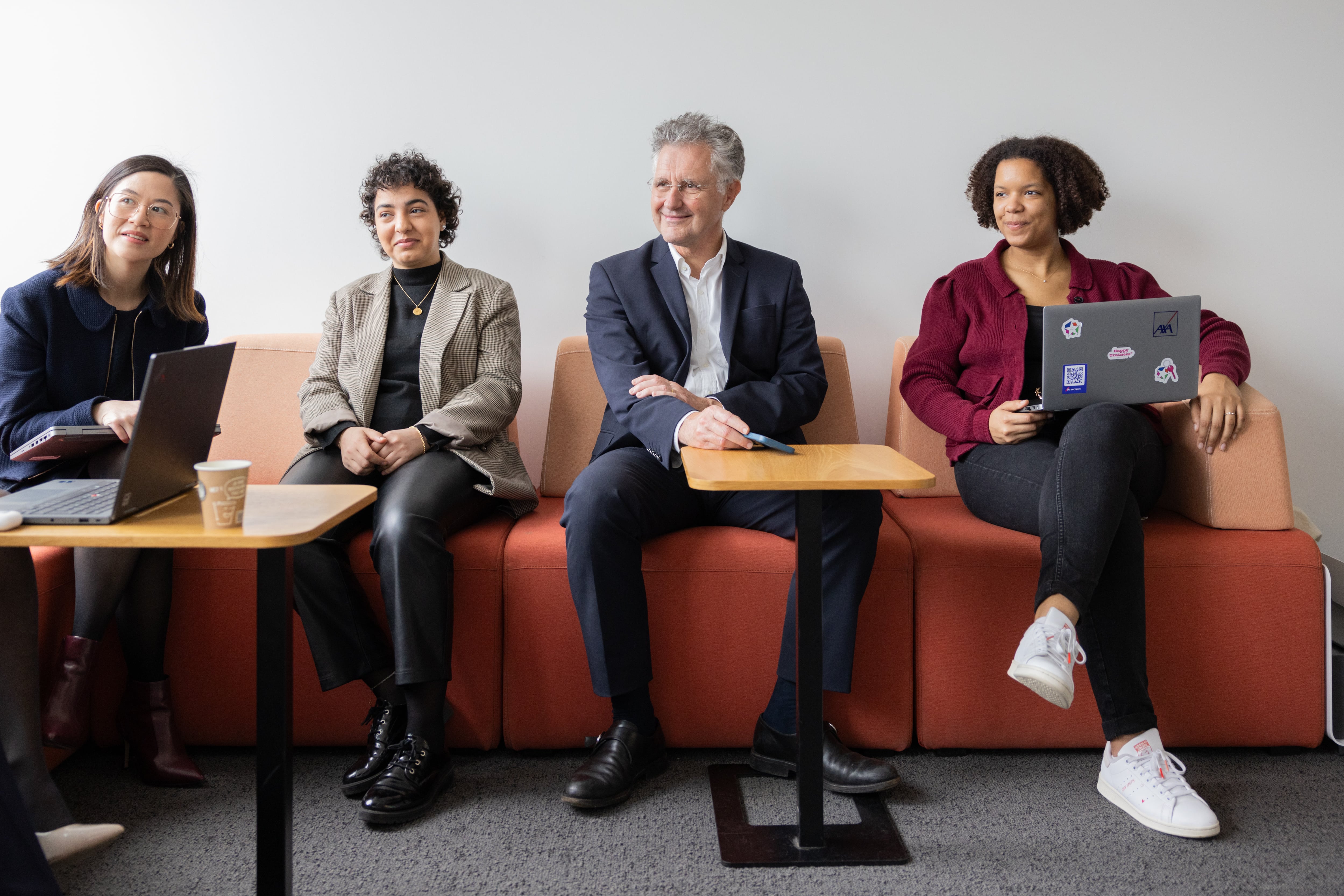 Personnes assises avec ordinateurs dans un salon de bureau