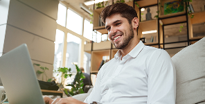 Homme utilisant un ordinateur portable sur un canapé