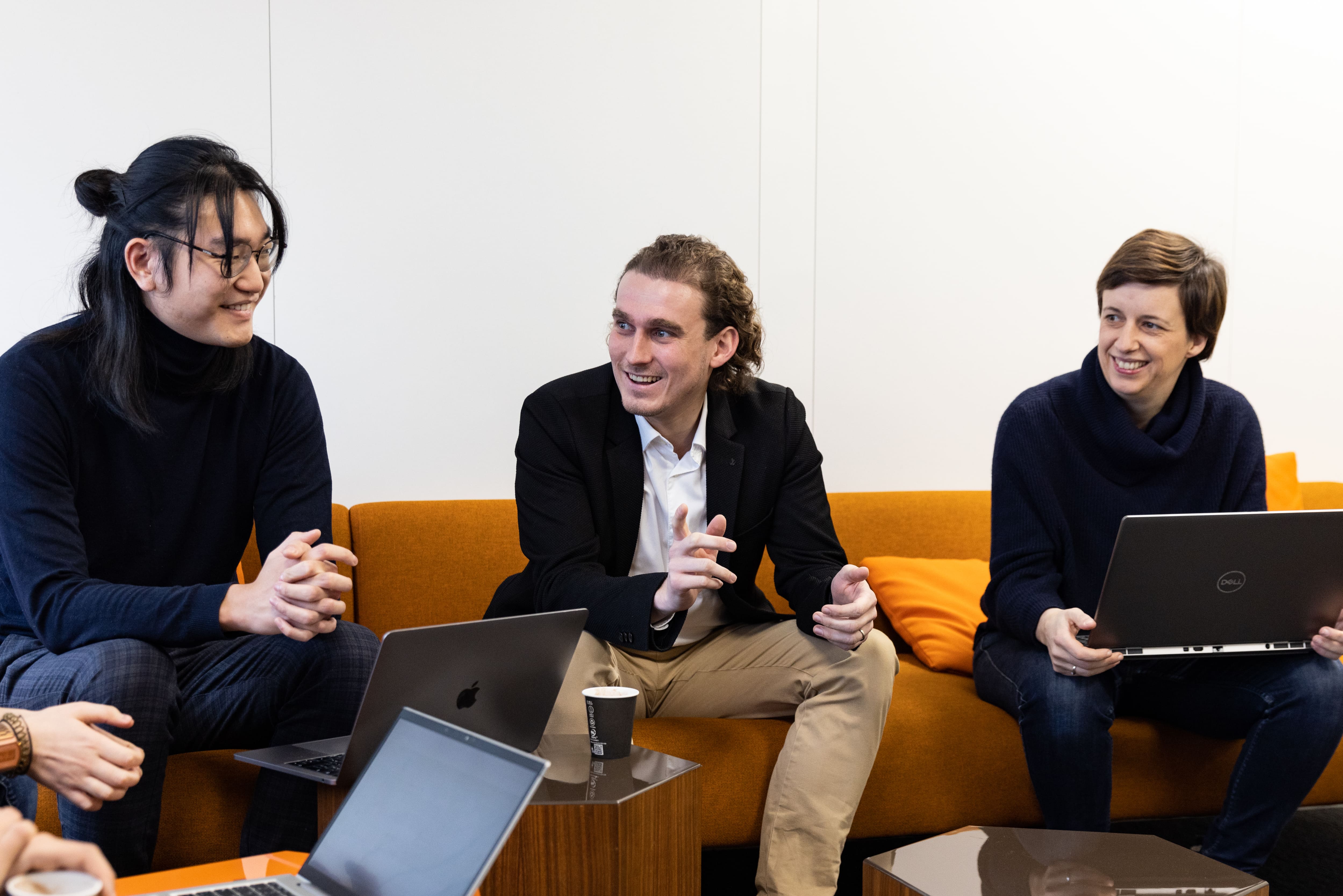 Groupe échangeant avec ordinateurs dans un salon de travail