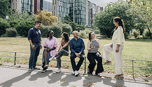 Groupe de personnes réunies dans un parc urbain.