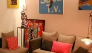 Salon multimédia avec affiches, coussins et éclairage