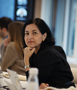 Person seated at desk resting chin on hand in meeting