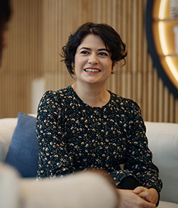 Person seated on sofa smiling in indoor setting