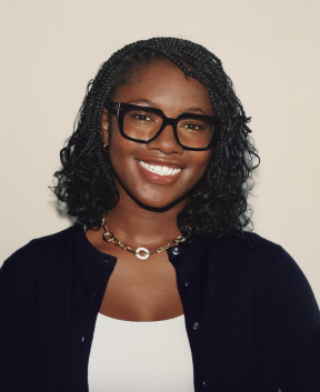 Portrait of person with glasses smiling on plain background