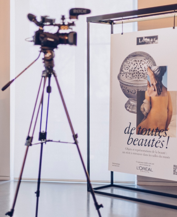 Camera on tripod filming poster display indoors
