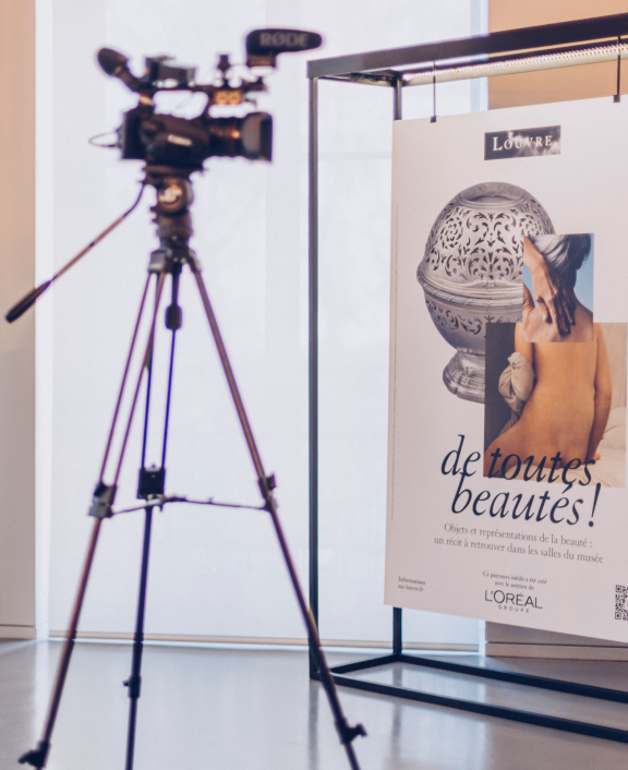 Camera on tripod filming poster display indoors