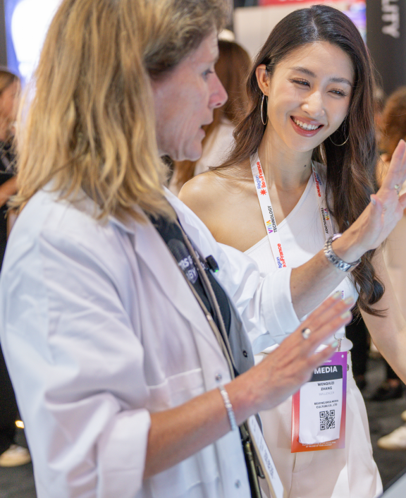Two people interacting at event booth, discussing something
